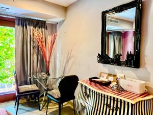 a room with a mirror and a desk and chairs at WiNNiNE Cozy Home in Bangkok