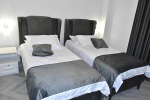 two beds in a hotel room withskirts at Hotel Monica in Bucharest