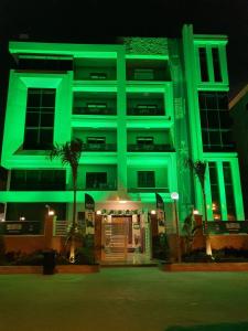 a building with green lights on it at night at كمبوند الكناريا عماره 81 in Sheikh Zayed