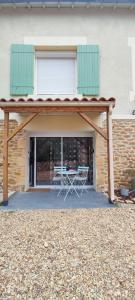 a patio with a table and chairs under a building at Studio Lindois in Lalinde