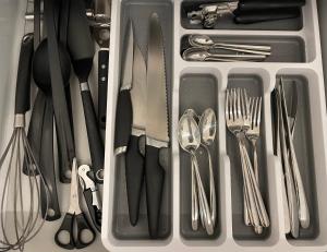 Boutique Cottage by Bishop's Stortford train station, easy to Stansted Airport & Parking في بيشوبس ستورتفورد: درج مملوء بالأدوات بما في ذلك الشوك والملاعق