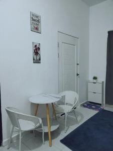 a table and chairs in a room with a table and chairs at Homestay Rezquna Deluxe Studio in Beaufort