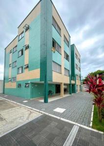 a building with blue and green paint on a street at Apartamento pé na areia no centro de Bertioga in Bertioga