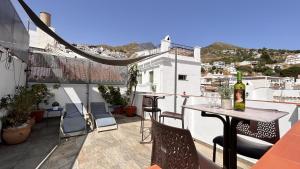 balcone con tavolo e bottiglia di vino di La posada del Cani a Cómpeta