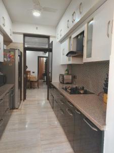 a kitchen with white cabinets and a wooden floor at Entire Vintage Apartment, Historic Heights Haven in Noida