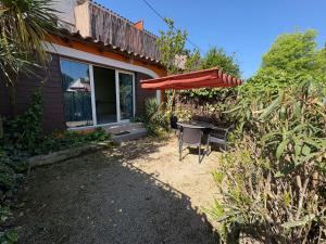 un patio con un tavolo e un ombrellone di Gites Le Patio34 a Lavérune