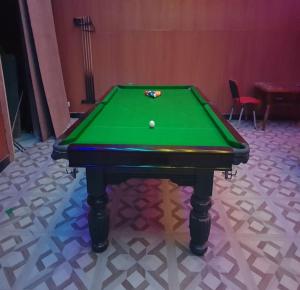 a green pool table with a ball on it at TNV Casita Inn in Yercaud