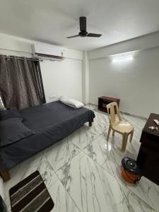 Un dormitorio con una cama, un escritorio y una silla. en S ROOMs, en Pithāpuram