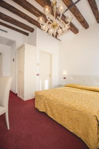 a bedroom with a bed and a chandelier at Locanda Ca' Lucrezia in Venice