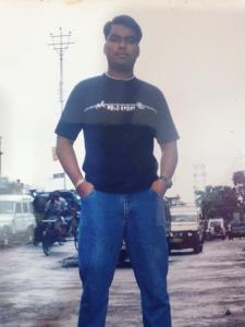 达卡Suite Property Insurance Group Of Company的一个男人站在街上，双手插在口袋里。