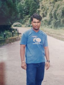 达卡Suite Property Insurance Group Of Company的一名身穿蓝色衬衫的男子站在路边