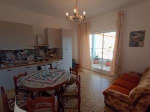 a kitchen and living room with a table and a kitchen and a dining room at Horizon Apt in Taormina