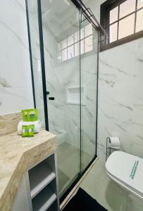 un bagno con doccia in vetro e WC di Camarote da Moacir !!!! a Capão da Canoa