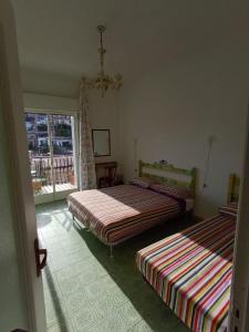 two beds sitting in a room with a window at Horizon Apt in Taormina +3 photos