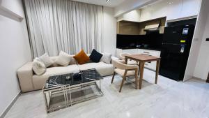 a living room with a couch and a table at كمبوند الكناريا عماره 81 in Sheikh Zayed