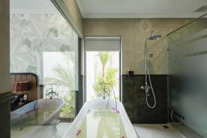 Xóm TramPolaris Resort & Spa的配有两个水槽、一个浴缸和一个淋浴的浴室