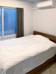 a white bed in a room with a window at カレラ豊平2nd in Sapporo