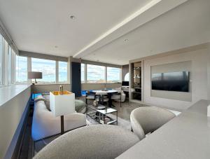 ein Wohnzimmer mit Sofa, Sesseln und Fernseher in der Unterkunft Large luxury apartment in Central Harrogate in Harrogate