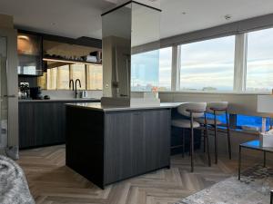 eine Küche mit einer Theke und einigen Hockern in der Unterkunft Large luxury apartment in Central Harrogate in Harrogate