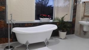 a bath tub and a sink in a bathroom at Tea Hills Bungalow in Hatton