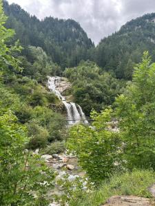 una cascada en medio de un valle con árboles en Faido Apartment, en Faido 14 fotos más