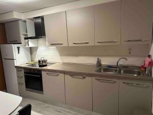 a kitchen with white cabinets and a sink at Faido Apartment in Faido