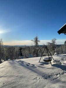 un patio cubierto de nieve con una tabla de snowboard en la nieve en New Cabin With Mountain View In Bittermark, Trysil, en Trysil