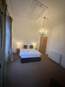 Un dormitorio con una cama y una lámpara de araña en Auld Bank House, en Braemar