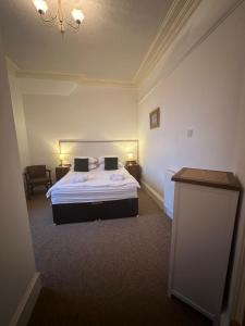 Habitación de hotel con cama y lámpara de araña. en Auld Bank House, en Braemar