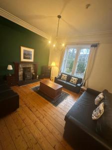 Una sala de estar con un sofá y una chimenea. en Auld Bank House, en Braemar