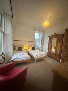 Una habitación con dos camas y una silla dentro. en Auld Bank House, en Braemar