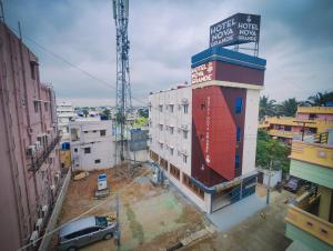 ein vor einem Gebäude geparktes Auto in der Unterkunft Hotel Nova Grande' in Hosur