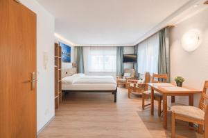 a hospital room with a bed and a table and chairs at Bolero Appartements in Zermatt
