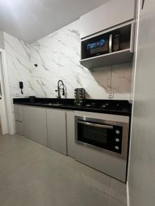 una cucina con lavello e fornello di Camarote da Moacir !!!! a Capão da Canoa