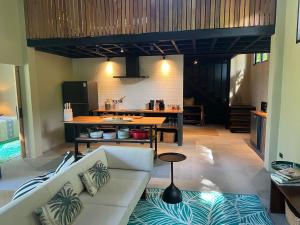 a living room with a white couch and a kitchen at Villa IL SEGRETO Koh Samui in Ban Lamai
