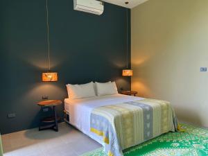 a bedroom with a bed and a table and two lights at Villa IL SEGRETO Koh Samui in Ban Lamai