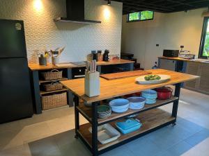 a kitchen with a wooden table with dishes on it at Villa IL SEGRETO Koh Samui in Ban Lamai