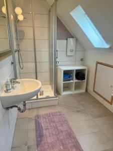 Ferienwohnung Lütte Koje beim Hinrichs Gasthof في Tümlauer Koog: حمام مع حوض ودش