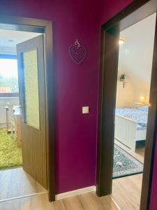 Ferienwohnung Lütte Koje beim Hinrichs Gasthof في Tümlauer Koog: باب أرجواني مع قلب على الحائط