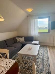 Ferienwohnung Lütte Koje beim Hinrichs Gasthof في Tümlauer Koog: غرفة معيشة بها أريكة وطاولة +24 صورة