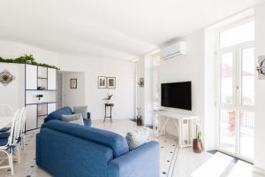 a living room with two blue chairs and a tv at Villa Elisa by My Villa Collection in Conca dei Marini