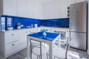 a blue and white kitchen with a blue table and chairs at Villa Elisa by My Villa Collection in Conca dei Marini
