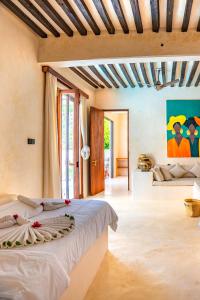 ein Schlafzimmer mit Bett und ein Wohnzimmer in der Unterkunft Tulia House Lamu in Lamu