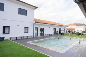 a group of people standing around a swimming pool in a yard at Coração de Viana AL in Viana do Castelo