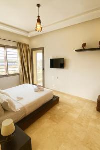 a bedroom with a bed and a tv on the wall at 3BR Near Airport Secure,Equipped stay and transit in Nouaseur