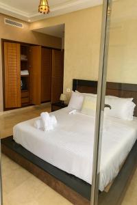 a bedroom with a large bed with white sheets and pillows at 3BR Near Airport Secure,Equipped stay and transit in Nouaseur +4 photos