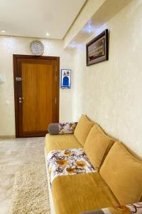 a living room with a couch and a wooden door at 3BR Near Airport Secure,Equipped stay and transit in Nouaseur
