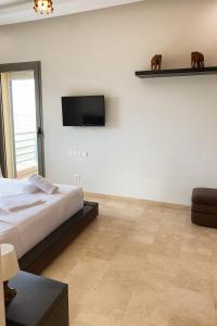 a bedroom with a bed and a television on a wall at 3BR Near Airport Secure,Equipped stay and transit in Nouaseur