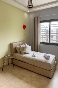 a bedroom with a bed and a table and a window at 3BR Near Airport Secure,Equipped stay and transit in Nouaseur +4 photos