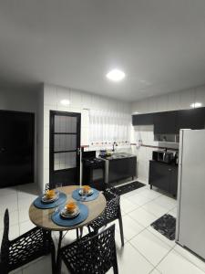 Una cocina con una mesa y sillas en una cocina. en Brisa do Sul, en Umuarama